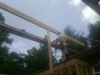 Carpenter setting a ridge beam over a new addition frame — Ice Dam Removal by Roofing Brothers in Colora