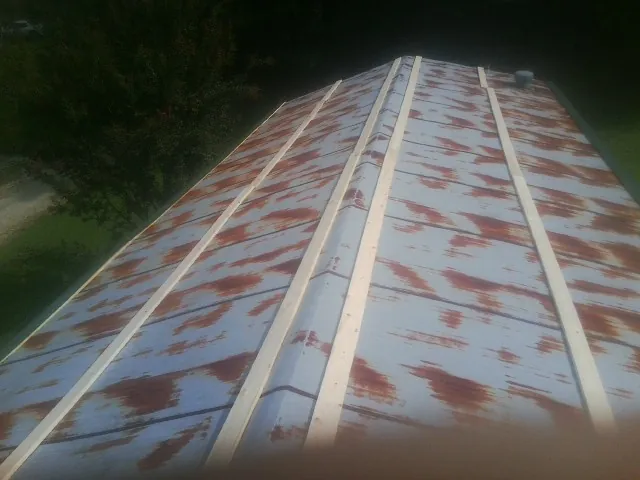Rusted metal roof panels with new wood purlins before replacement — Storm Damage Roof Repair in Colora by Roofing Brothers